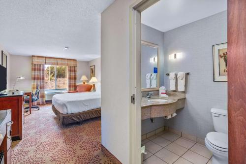 a hotel room with a bed and a bathroom at Hilton Garden Inn Starkville in Starkville