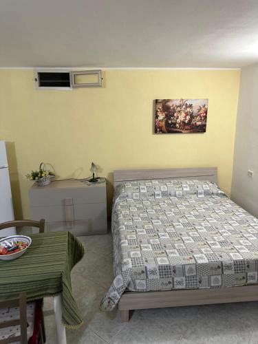ein Schlafzimmer mit einem Bett und einem Tisch darin in der Unterkunft Carrube House in Andrano