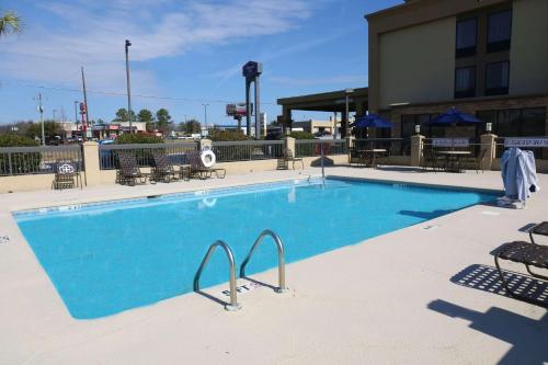 a large blue swimming pool in front of a building at Hampton Inn Sumter in Sumter