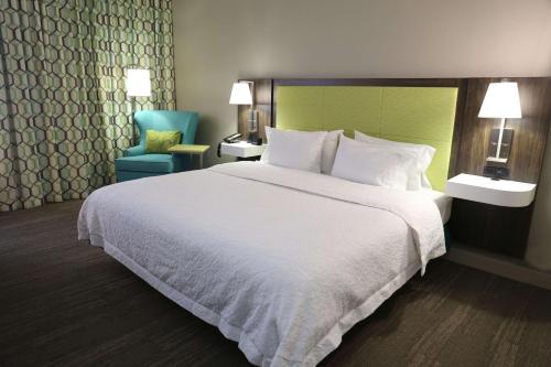 una habitación de hotel con una cama grande y una silla en Hampton Inn Sumter en Sumter