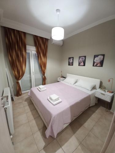 ein Schlafzimmer mit einem großen weißen Bett und einem Fenster in der Unterkunft Caldo Deluxe Apartment Thessaloniki in Thessaloniki