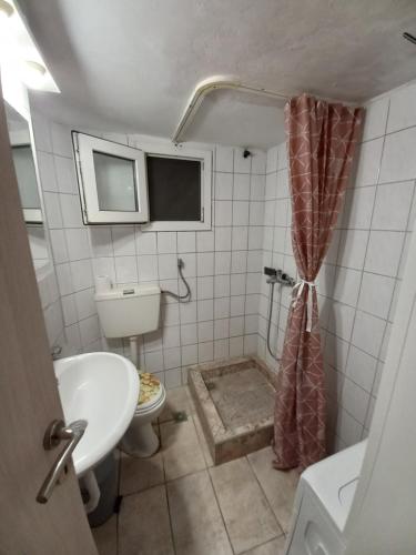 ein Bad mit einem WC, einem Waschbecken und einer Dusche in der Unterkunft Caldo Deluxe Apartment Thessaloniki in Thessaloniki