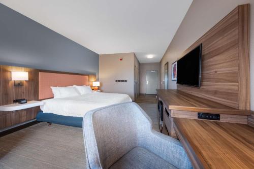 a hotel room with a bed and a flat screen tv at Hampton Inn Saint Robert in Saint Robert