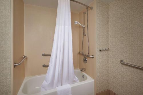 baño con ducha con cortina blanca en Hampton Inn Shrewsbury, en Shrewsbury