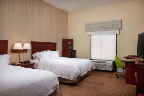 a hotel room with two beds and a television at Hampton Inn Shrewsbury in Shrewsbury