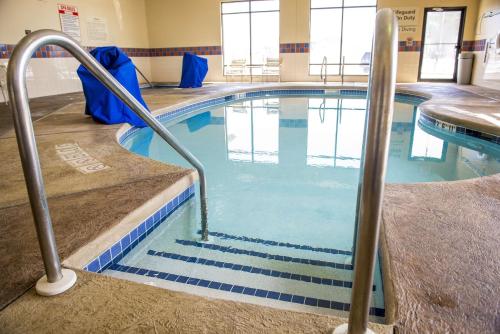 a swimming pool with blue water in a building at Hampton Inn Plover-Stevens Point in Plover