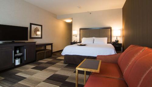 een hotelkamer met een bed en een flatscreen-tv bij Hampton Inn Orange City in Orange City