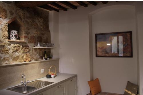 a kitchen with a sink and a stone wall at Camere La Carbonaia in Pienza