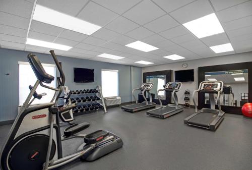 a gym with several treadmills and machines in a room at Hampton Inn & Suites by Hilton Syracuse Dewitt in East Syracuse