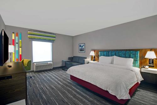 a hotel room with a bed and a television at Hampton Inn & Suites by Hilton Syracuse Dewitt in East Syracuse