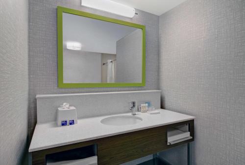 a bathroom with a sink and a mirror at Hampton Inn & Suites by Hilton Syracuse Dewitt in East Syracuse