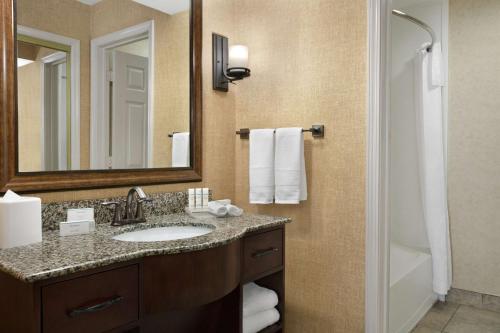 a bathroom with a sink and a mirror and a shower at Homewood Suites Syracuse-Liverpool in Liverpool