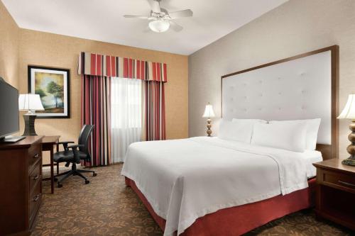 a hotel room with a large bed and a desk at Homewood Suites Syracuse-Liverpool in Liverpool