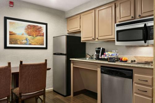a kitchen with a sink and a refrigerator at Homewood Suites Syracuse-Liverpool in Liverpool