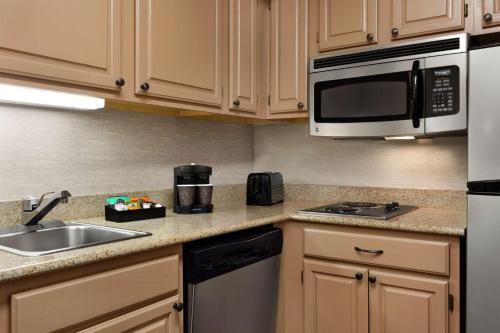 a kitchen with a sink and a microwave at Homewood Suites Syracuse-Liverpool in Liverpool