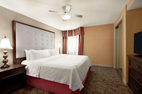 a hotel room with a bed and a television at Homewood Suites Syracuse-Liverpool in Liverpool