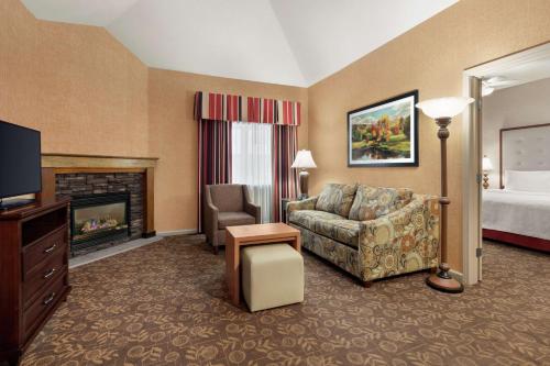 a hotel room with a couch and a fireplace at Homewood Suites Syracuse-Liverpool in Liverpool