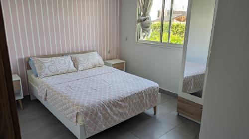 a small bedroom with a bed and a window at Perla à 200 m de la plage in Saidia 