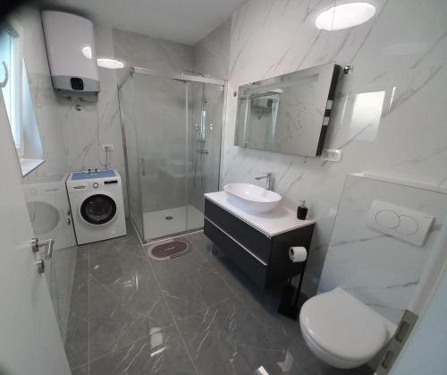 a bathroom with a sink and a toilet and a shower at Apartment Sunset in Trogir