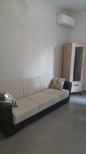 a couch sitting in a living room with a window at I Faraglioni Comfort Rooms in Terrasini