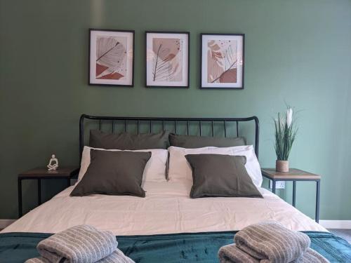 ein Schlafzimmer mit einem Bett mit drei Bildern an der Wand in der Unterkunft Homely 2 bed duplex with a river view in Southampton