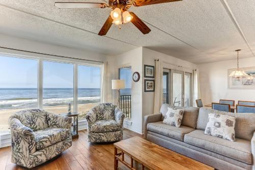 a living room with a couch and chairs and the ocean at Oceans Of Amelia - 309 in Fernandina Beach