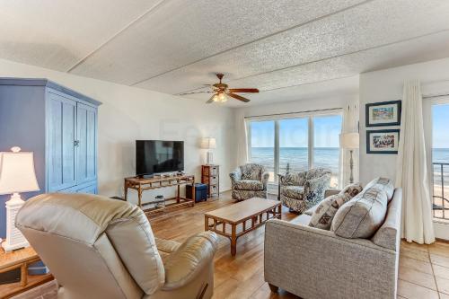 a living room with a couch and a tv at Oceans Of Amelia - 309 in Fernandina Beach