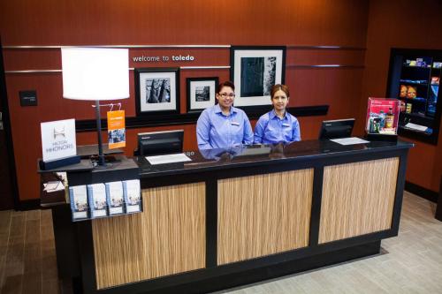 two people standing at a counter in a store at Hampton Inn & Suites Toledo/Westgate in Toledo