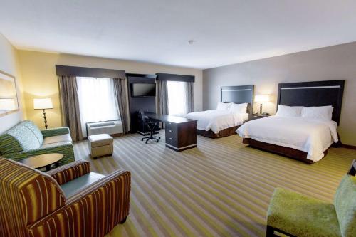 a hotel room with two beds and a couch at Hampton Inn & Suites Toledo/Westgate in Toledo