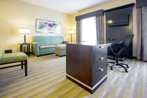a hotel room with a desk and a living room at Hampton Inn & Suites Toledo/Westgate in Toledo