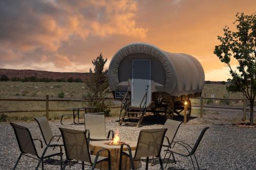 un gruppo di sedie e un tavolo di fronte a una tenda di Broken Spur Inn & Steakhouse a Torrey