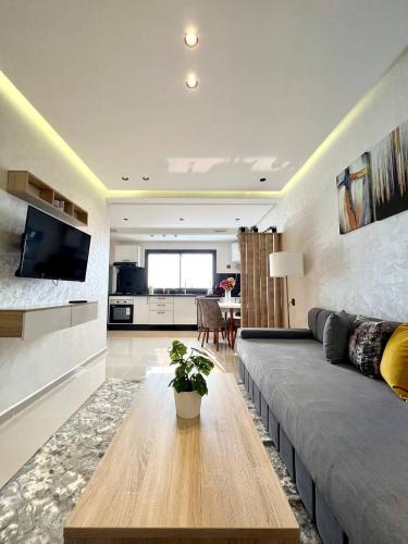 a living room with a large couch and a table at Oasis Mehdia vue sur mer in Kenitra
