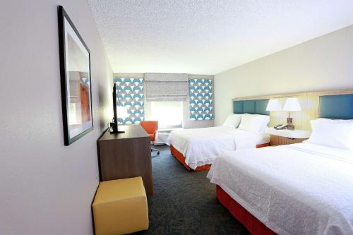a hotel room with two beds and a desk at Hampton Inn & Suites Tampa-Wesley Chapel in Wesley Chapel