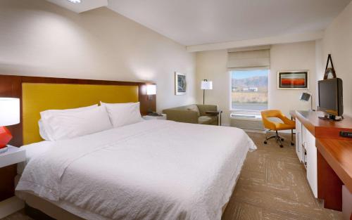 a hotel room with a bed and a desk and a television at Hampton Inn Tremonton in Tremonton