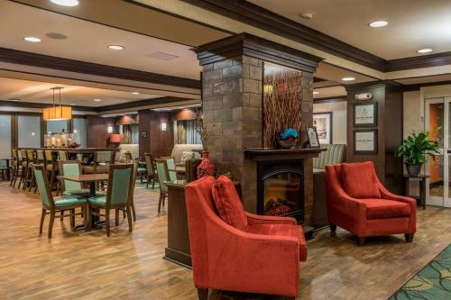 a lobby with a fireplace and tables and chairs at Hampton Inn New Albany in New Albany