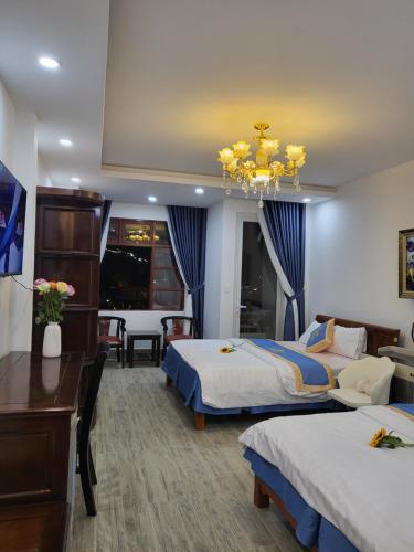 a hotel room with two beds and a chandelier at Huong Mai Hotel in Da Lat