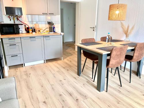een keuken en eetkamer met een tafel en stoelen bij Bright & central for 4 incl workspace in Bochum