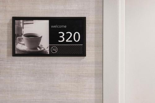 a clock on a wall with a cup of coffee at Hampton Inn New Albany in New Albany