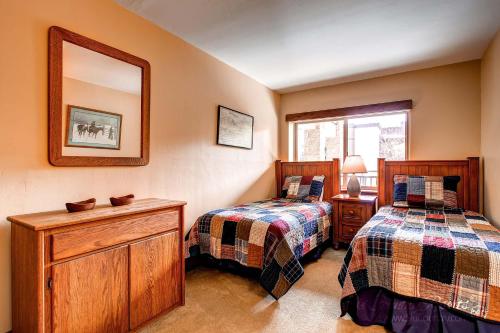 1 Schlafzimmer mit 2 Betten und einem Wandspiegel in der Unterkunft Escape to Serene Bliss, Enjoy Breck's Beauty at this Luxurious Condo PA202 in Breckenridge