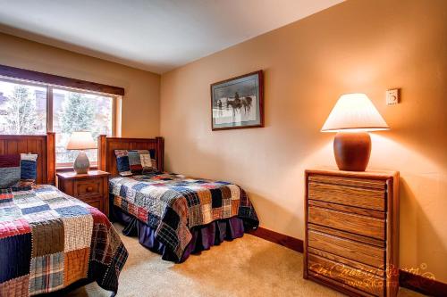 1 Schlafzimmer mit 2 Einzelbetten und einem Fenster in der Unterkunft Escape to Serene Bliss, Enjoy Breck's Beauty at this Luxurious Condo PA202 in Breckenridge