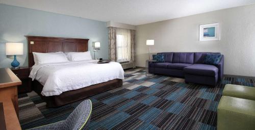 a hotel room with a bed and a couch at Hampton Inn Tucson-Airport in Tucson