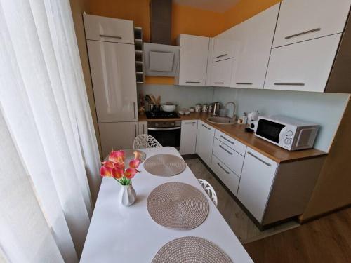 une cuisine avec une table avec un vase de fleurs dessus dans l'établissement Baroness apartments, à Riga