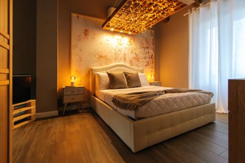 een slaapkamer met een wit bed en een kroonluchter bij Agriturismo Agli ulivi in Saluzzo