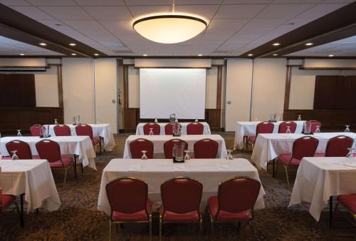 a conference room with tables and chairs and a white screen at DoubleTree Suites by Hilton Tucson-Williams Center in Tucson