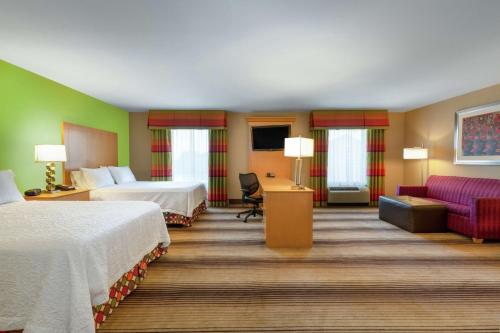 um quarto de hotel com duas camas e um sofá em Hampton Inn Texarkana em Texarkana