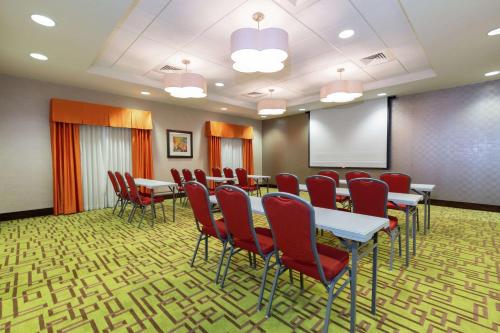 Una sala de conferencias con mesas, sillas y una pantalla. en Hampton Inn Texarkana, en Texarkana