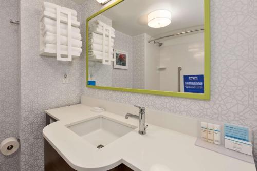 a bathroom with a white sink and a mirror at Hampton Inn Traverse City in Traverse City
