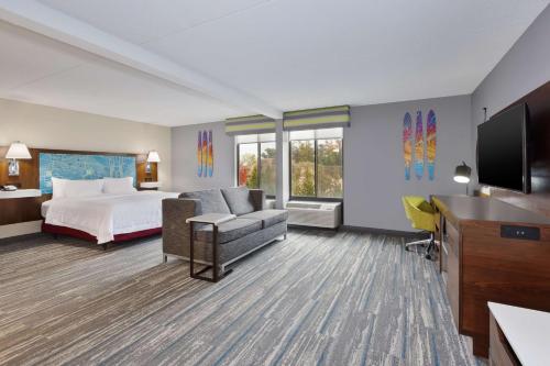 a hotel room with a bed and a flat screen tv at Hampton Inn Traverse City in Traverse City