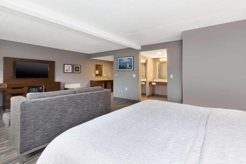 a hotel room with a bed and a couch at Hampton Inn Traverse City in Traverse City