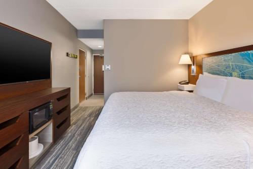 a hotel room with a bed and a flat screen tv at Hampton Inn Traverse City in Traverse City